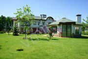 Беседка с барбекю на участке за основным домом